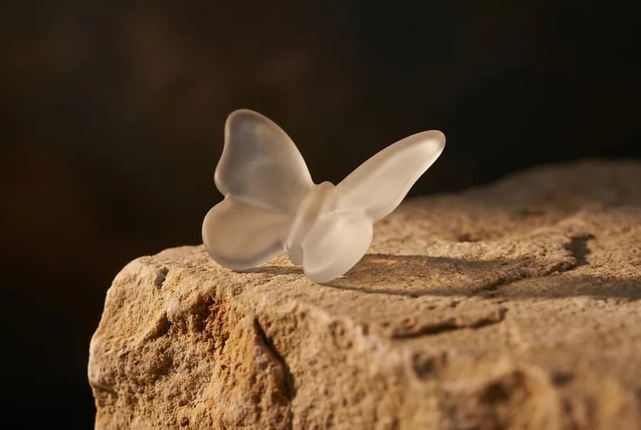 A frosted glass butterfly, the shape of a thyroid, resting on a limestone block.